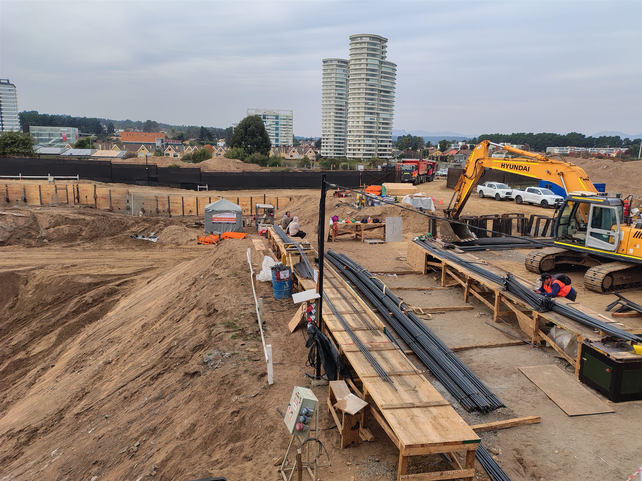 Obra de construcción en ejecución con maquinaria, materiales y equipos en terreno